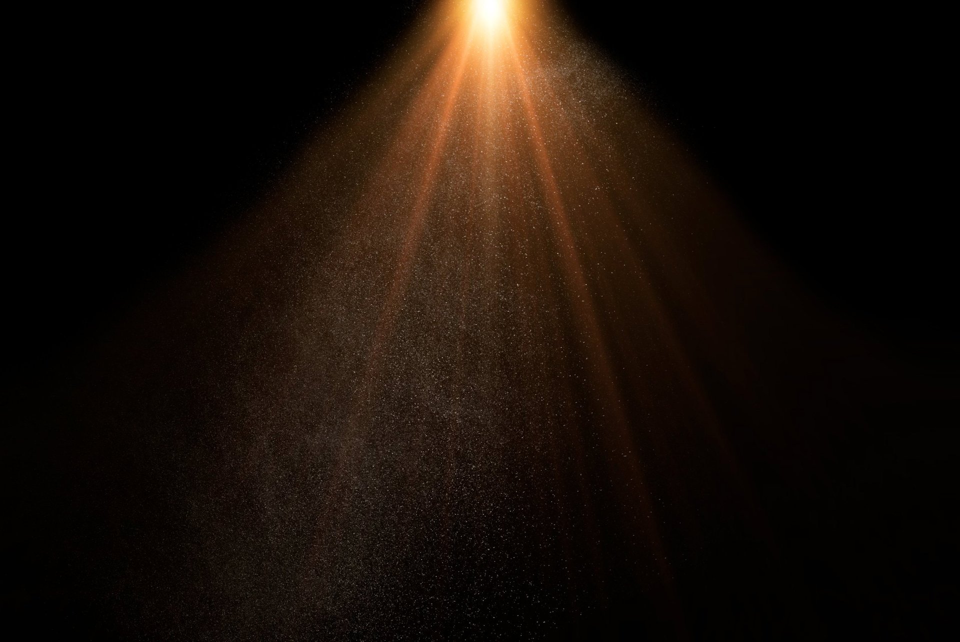 Rayos de luz divina dorada con partículas en fondo oscuro